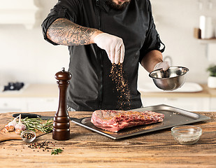 Image showing Man cooking meat steak on kitchen