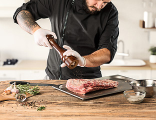 Image showing Man cooking meat steak on kitchen