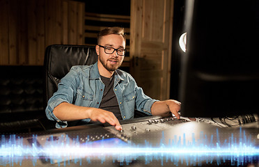 Image showing sound engineer at recording studio mixing console