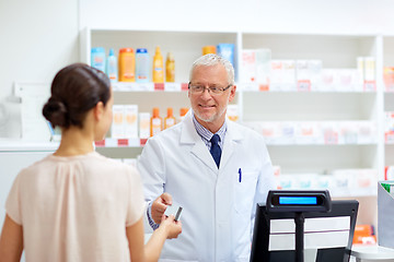 Image showing apothecary taking customer credit card at pharmacy