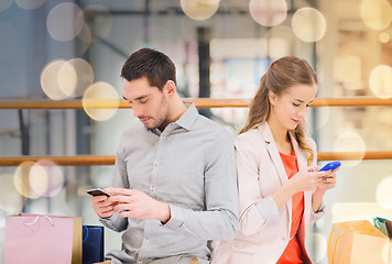 Image showing couple with smartphones and shopping bags in mall