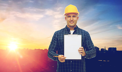 Image showing male builder in yellow hard hat with clipboard