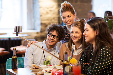 Image showing friends taking selfie by smartphone at bar or cafe