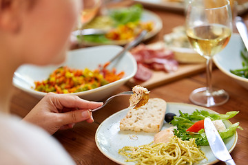 Image showing hands of woman eating pasta with chicken