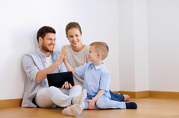 Image showing family with tablet pc at new home making high five