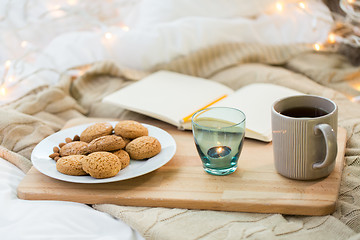 Image showing cookies, tea and candle in holder at home