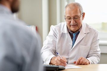 Image showing doctor writing prescription for patient at clinic