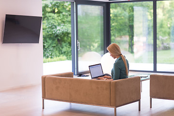 Image showing Young woman using laptop at home