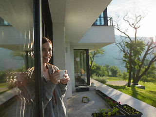 Image showing woman drinking coffee in front of her luxury home villa