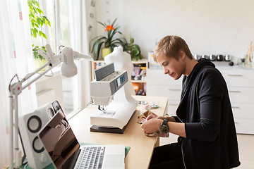 Image showing fashion designer with sewing machine at studio