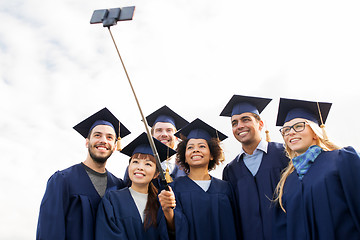 Image showing group of happy students or graduates taking selfie