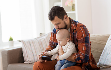 Image showing father and baby boy with smartphone at home