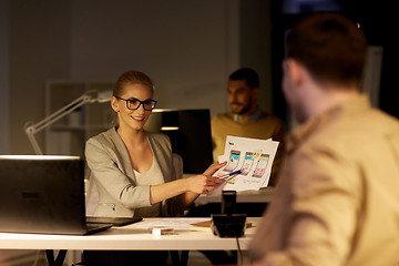 Image showing workers with user interface mockup late at office