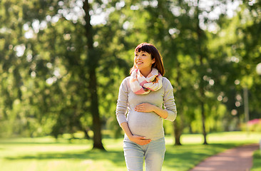Image showing happy pregnant asian woman walking at park