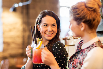 Image showing happy friends clinking drinks at restaurant