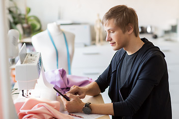 Image showing fashion designer with tablet pc working at studio