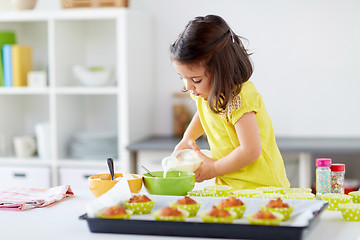 Image showing little girl baking muffins at home