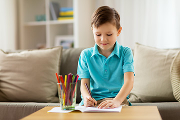 Image showing boy with notebook and pencils drawing at home