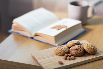 Image showing oat cookies, almonds and book on table at home