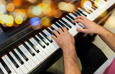 Image showing close up of male hands playing piano