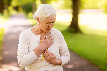 Image showing senior woman feeling sick at summer park