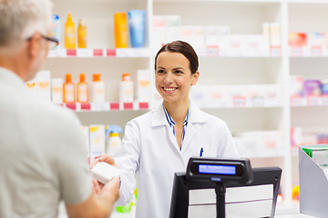 Image showing apothecary selling drug to senior man at pharmacy