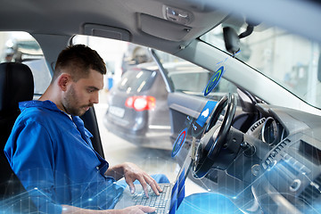 Image showing mechanic man with laptop making car diagnostic