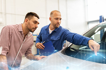 Image showing auto mechanic with clipboard and man at car shop