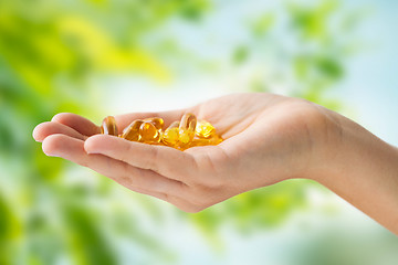 Image showing hand holding cod liver oil capsules