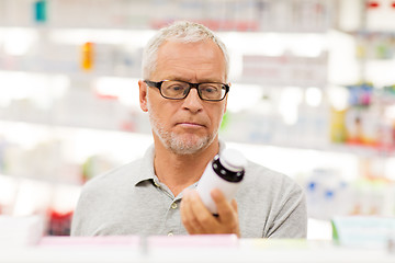 Image showing senior male customer with drug at pharmacy