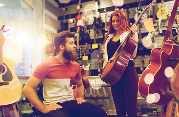 Image showing couple of musicians with guitar at music store