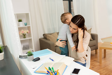 Image showing mother student with baby learning at home