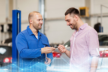 Image showing auto mechanic giving key to man at car shop