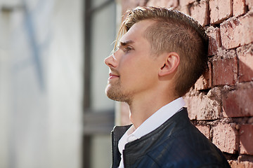 Image showing portrait of man in leather jacket over brick wall