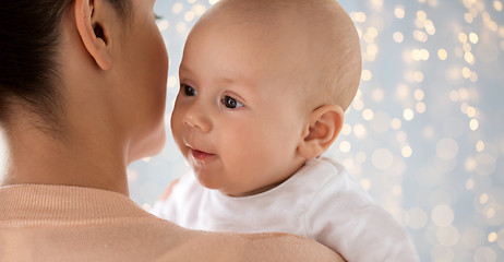 Image showing close up of happy baby with mother over lights