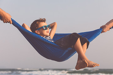 Image showing Happy little boy relaxing on the beach at the day time