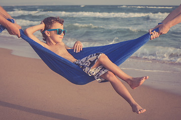 Image showing Happy little boy relaxing on the beach at the day time