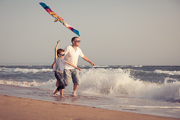 Image showing Father and son playing on the beach at the day time.