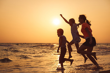 Image showing Happy children playing on the beach at the sunset time.