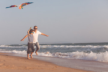 Image showing Father and son playing on the beach at the day time.