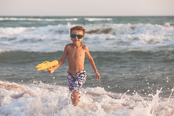 Image showing One happy little boy playing on the beach at the day time.