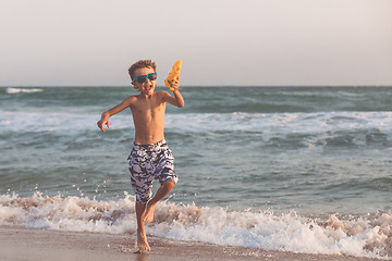 Image showing One happy little boy playing on the beach at the day time.