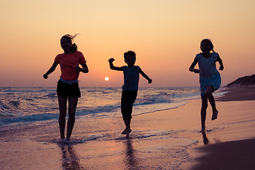 Image showing Happy children playing on the beach at the sunset time.