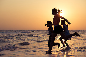 Image showing Happy children playing on the beach at the sunset time.