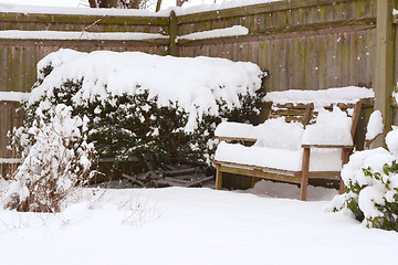 Image showing Deep snow on a bench and shrubs in rural garden 