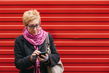 Image showing Adult woman with smartphone on street