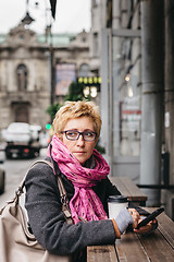 Image showing Woman with smartphone looking away