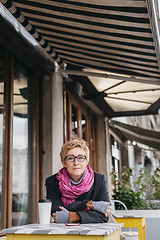 Image showing Dreamy woman with phone in cafe