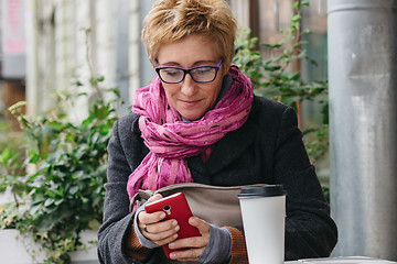 Image showing Smiling woman with phone in cafe