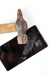 Image showing An old hammer and smartphone